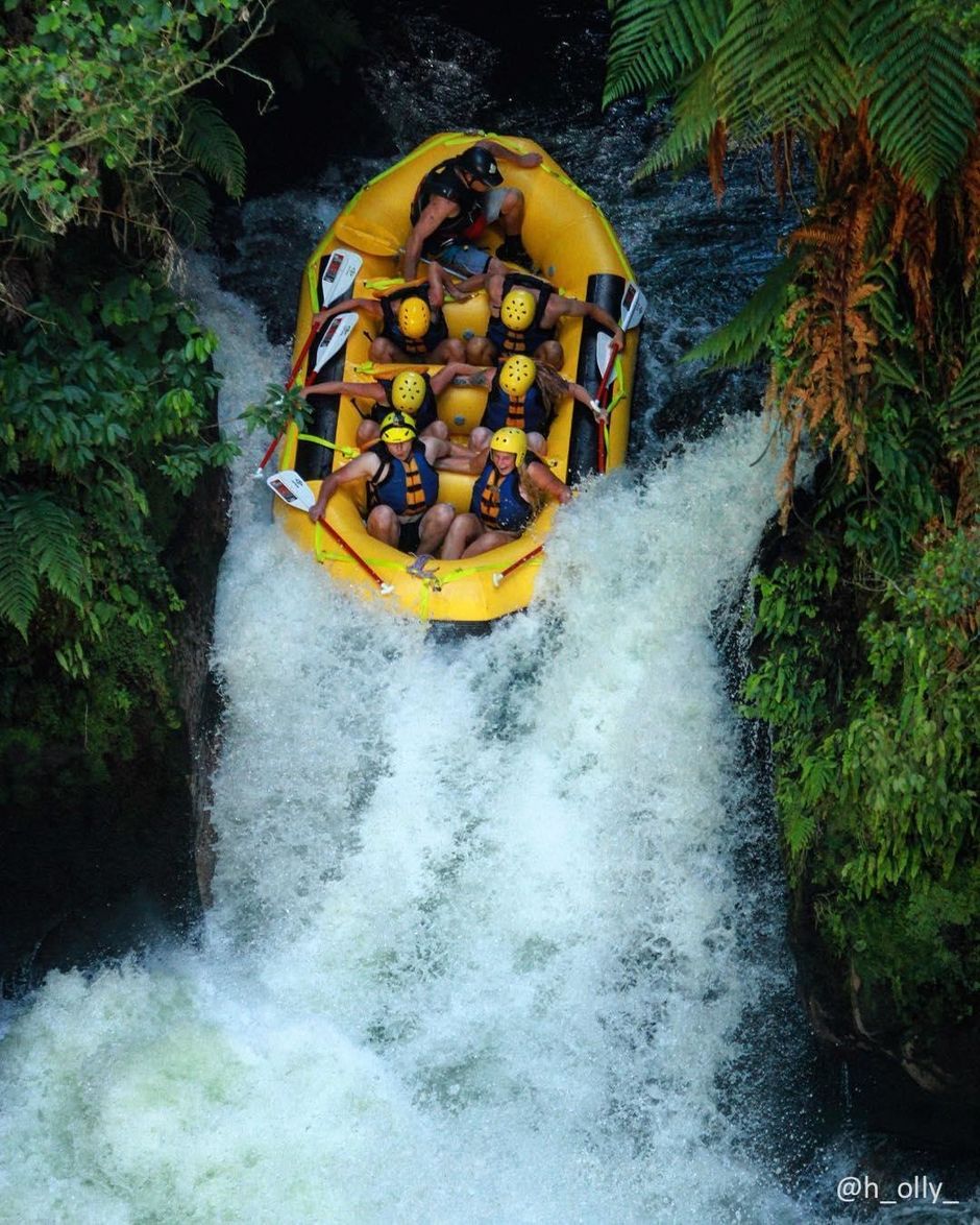Whitewater rafters brace themselves for a waterfall while rafting the Kaituna River