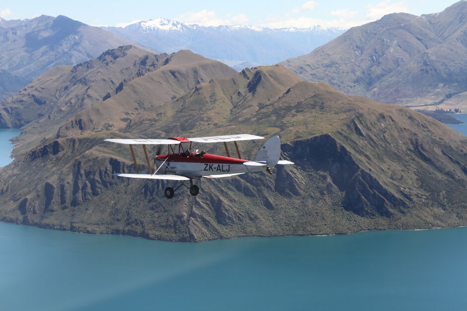 ZK-ALJ takes a flight over the lake at Wānaka.