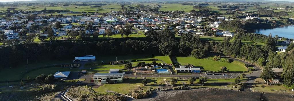 Aerial shot looking back at Opunake Beach and the Opunake Beach Holiday Park with Opunake Lake and the majestic Mt Taranaki in the background.
