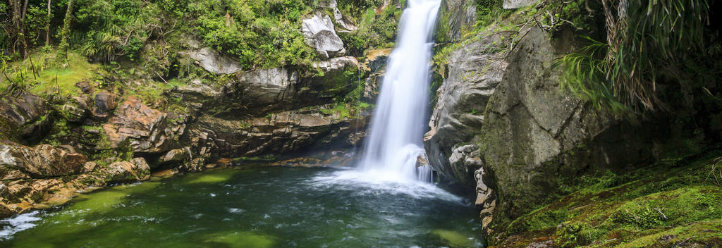 A short walk through native bush leads to the cascading Wainui Falls.