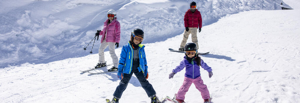 Family skiing down the field on Mt Hutt in Canterbury, New Zealand