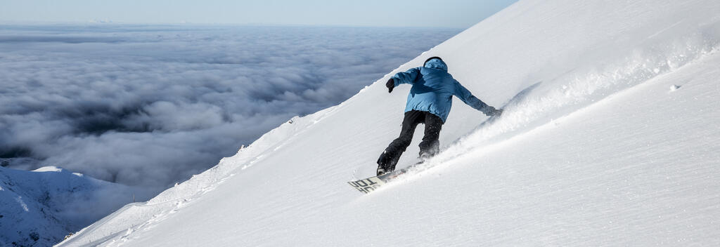 Snowboarder enjoying the fresh snow powder on Mt Hutt ski field in Canterbury, New Zealand