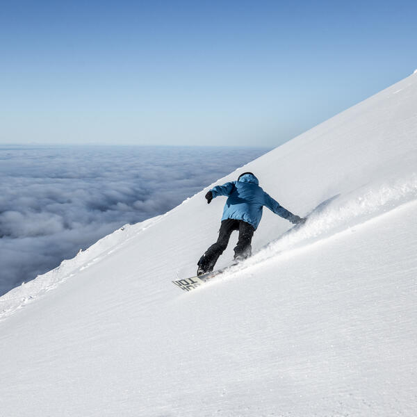 Snowboarder enjoying the fresh snow powder on Mt Hutt ski field in Canterbury, New Zealand