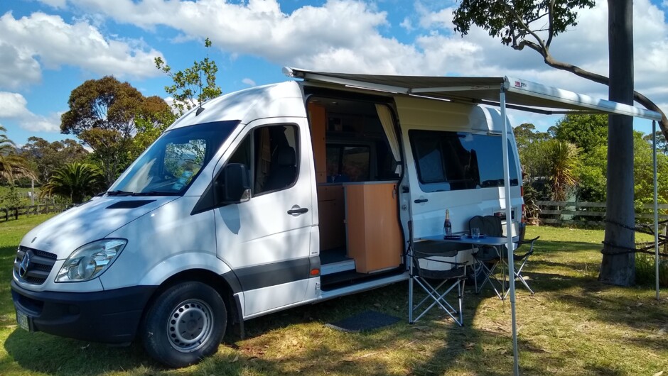 Mercedes Sprinter 2 berth with awning and outdoor chairs and table.