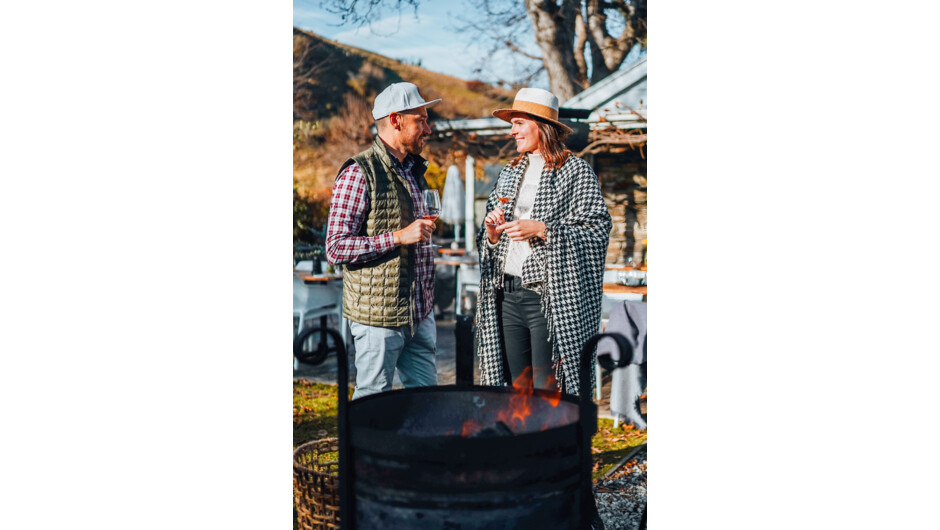 Couple enjoying their private wine tasting next to the fire.