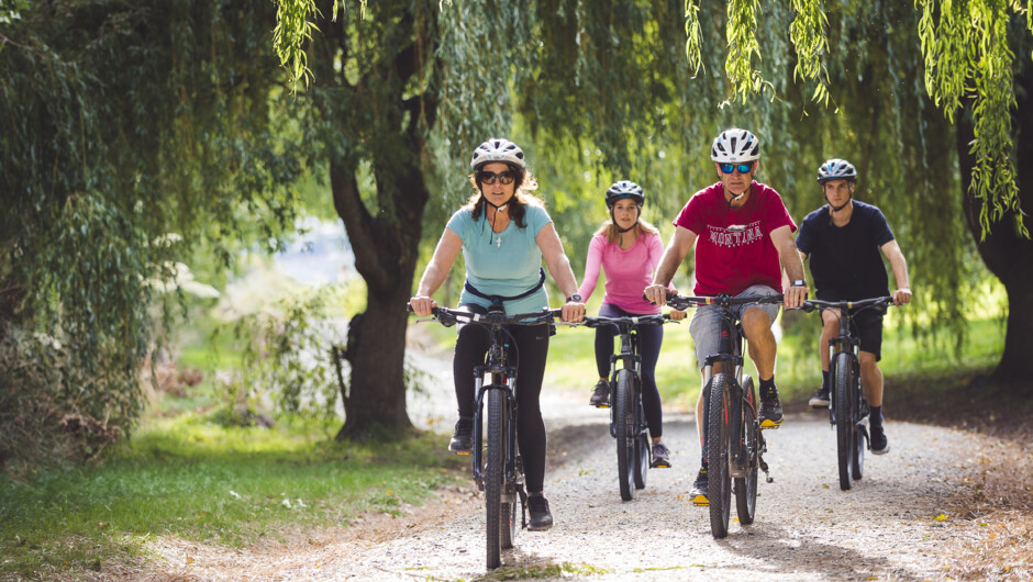 Riders on hardtail mountain bikes cruising the Queenstown Trail.