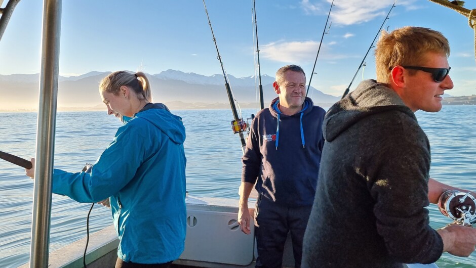 Fishing in Kaikoura with the snow capped Kaikoura Seaward Mountain Ranges towering in the background.