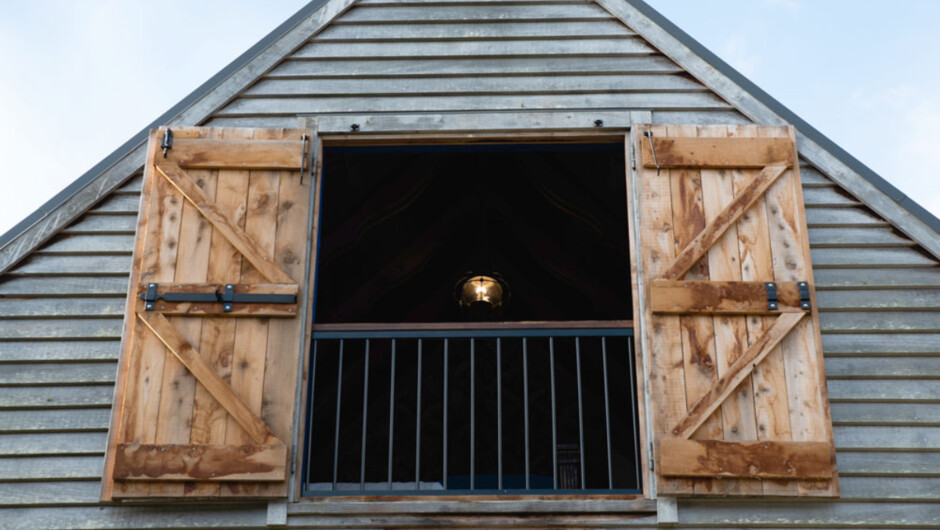 Barn doors open allowing fresh air and beautiful natural light in upstairs bedroom.