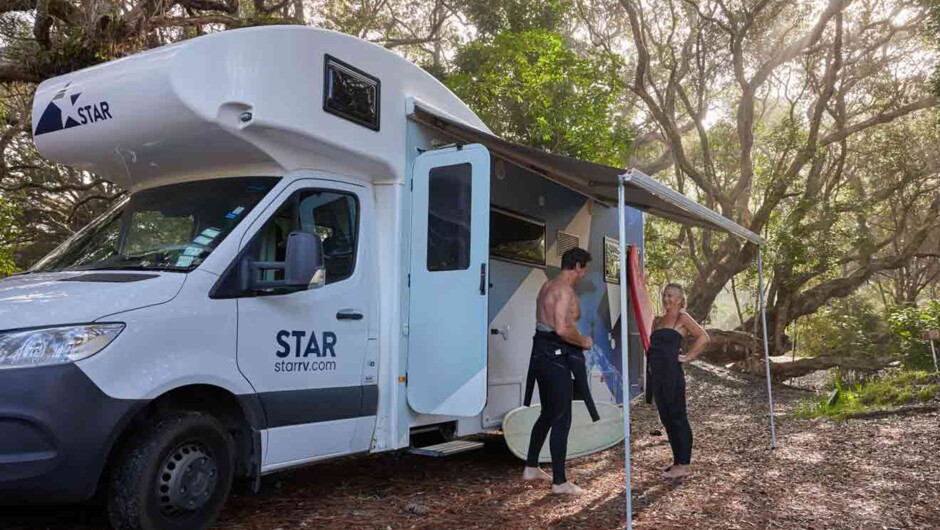 Couple under sun awning of Star RV Polaris 6 motorhome