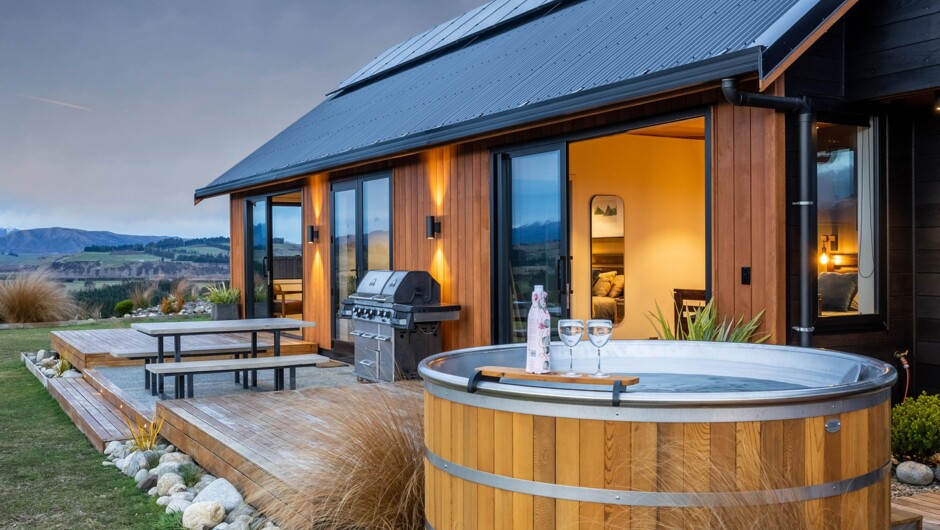 Outside dining area, large BBQ and solar panels. A heated outdoor shower is also located in the space to the right of this photo.