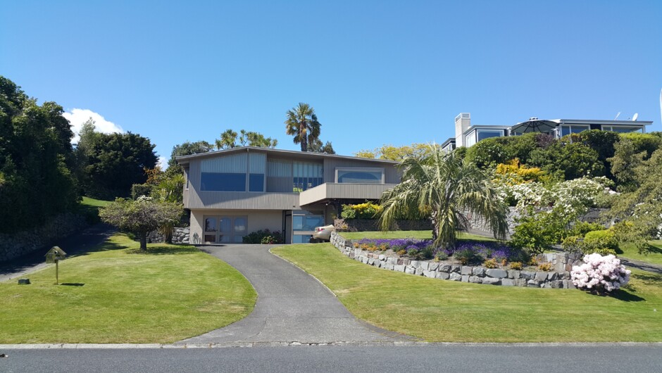 Front view of home from the street, set in 2/3's of an acre of established grounds