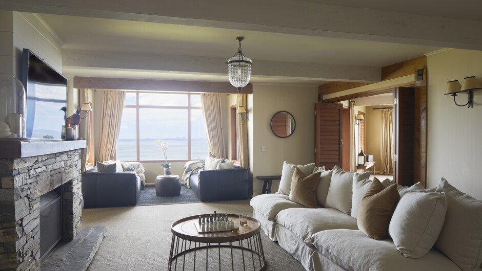 Lounge room with smart TV, wood burner fireplace and ocean views.