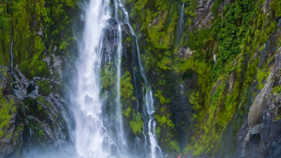 Guests explore by zodiac at Sterling Falls, Fiordlands National Park, Milford Sound, South Island, New Zealand.