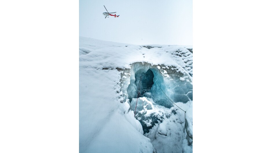 Helicopter flying over Ice Cave on Tasman Glacier