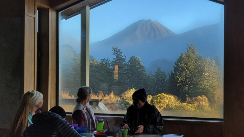 Enjoy a cosy breakfast in Waihohonu Hut in Tongariro National Park, with stunning views.