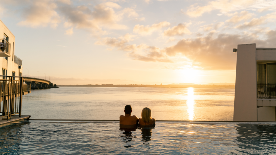 Hotel guests watching the sunset over the stunning infinity pool.