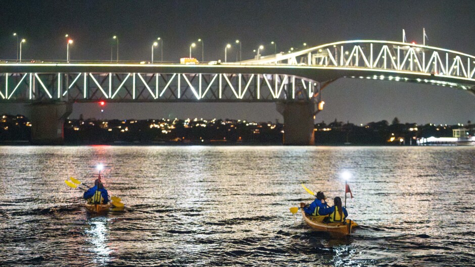 Paddling under the iconic Auckland Harbour Bridge at night.