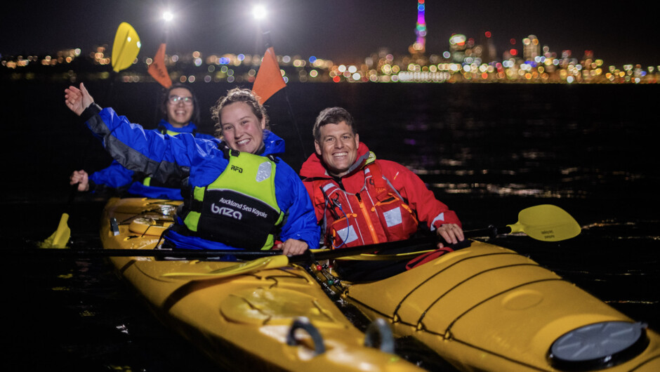 Kayakers on the water at night in Auckland.