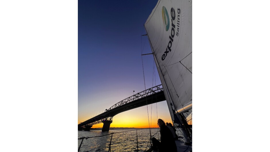 Watching the sun set under Auckland's Harbour Bridge on Explore's Auckland Harbour Dinner Cruise