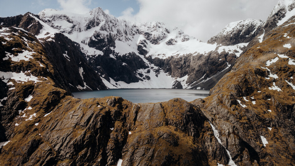 Alpine lakes, tarns and snow covered peaks enroute to Milford Sound.