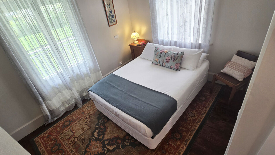 The Pūriri Room - Queen Room with Ensuite and Verandah access on the Ground Floor at Riverhead Villa.