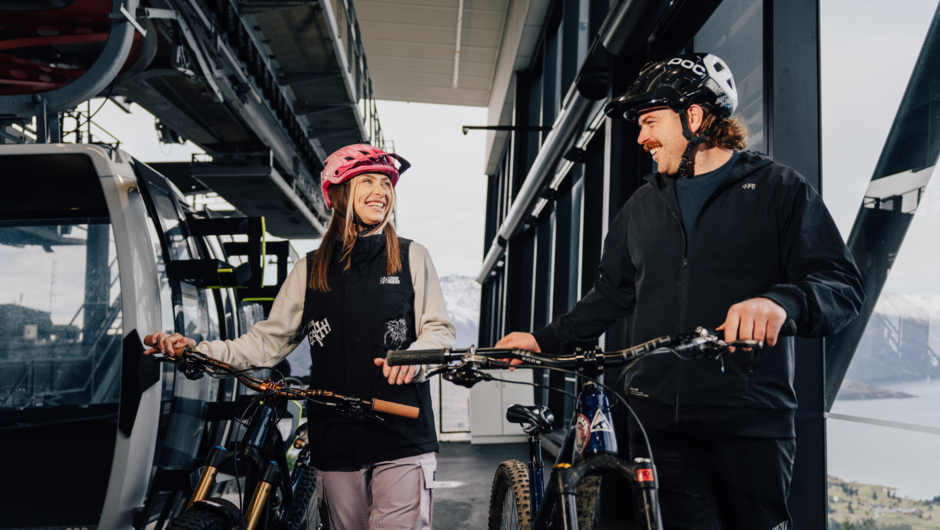 Two riders excited to be at the top of the Gondola with their bikes.