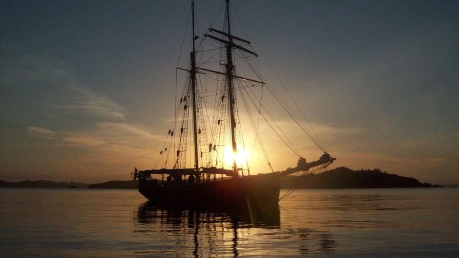 Sunset across the anchored ship; the end of a beautiful day in the Bay of Islands.