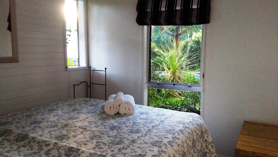 Walnut Cottage bedroom looking out to the delicious saltwater pool.